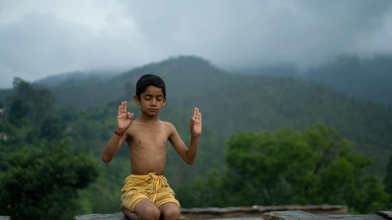 Person meditating peacefully in a beautifully lit, serene environment.